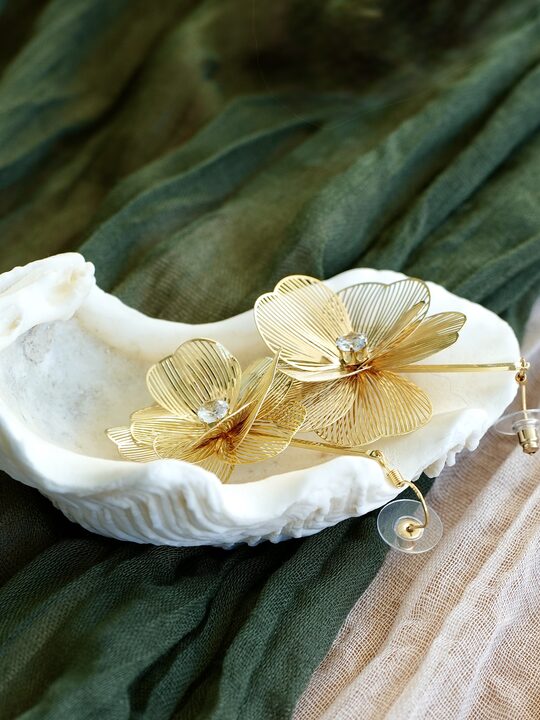 Goldener Blütenohrschmuck von Herzglanz in einer Muschelschale