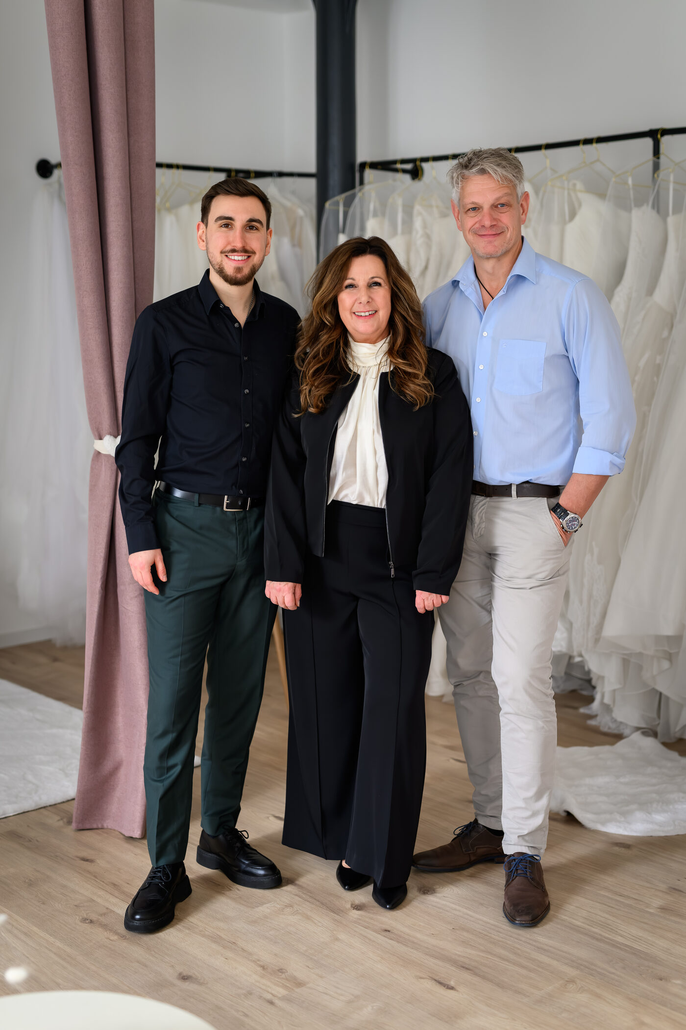 Die Familie hinter der Herzspinnerei vor den Kleiderstangen der Boutique