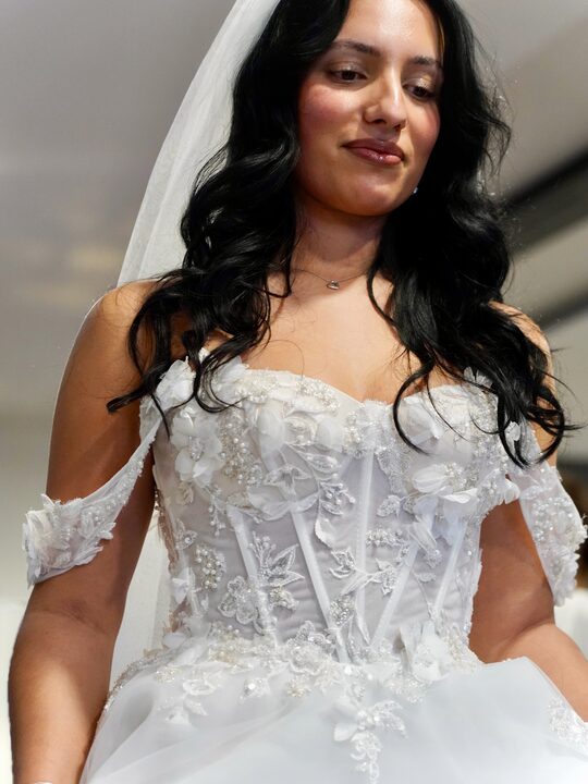 Braut im bestickten Corsagenkleid mit Schleier und Blütenapplikationen